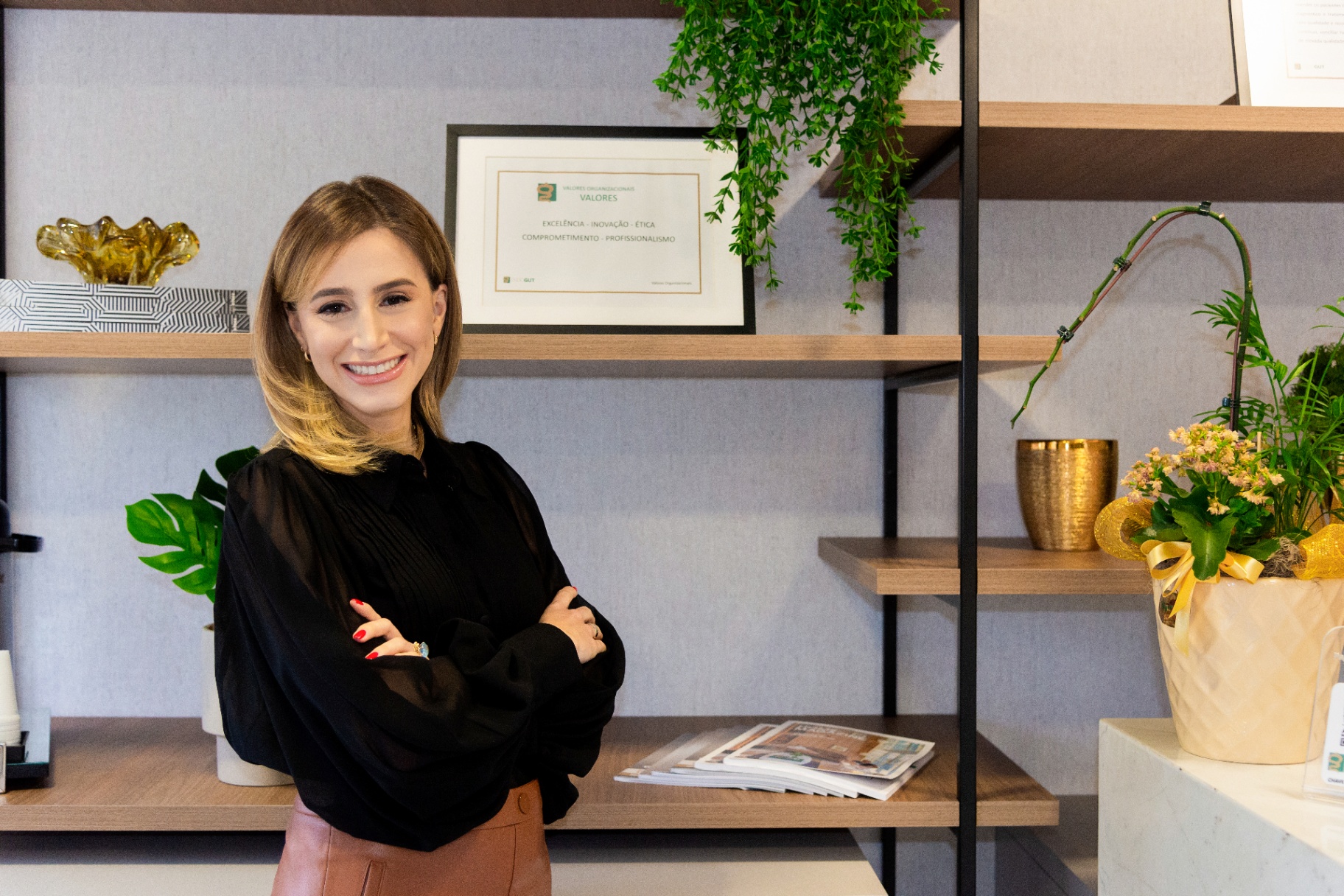 Doctor posing confidently by the office shelves