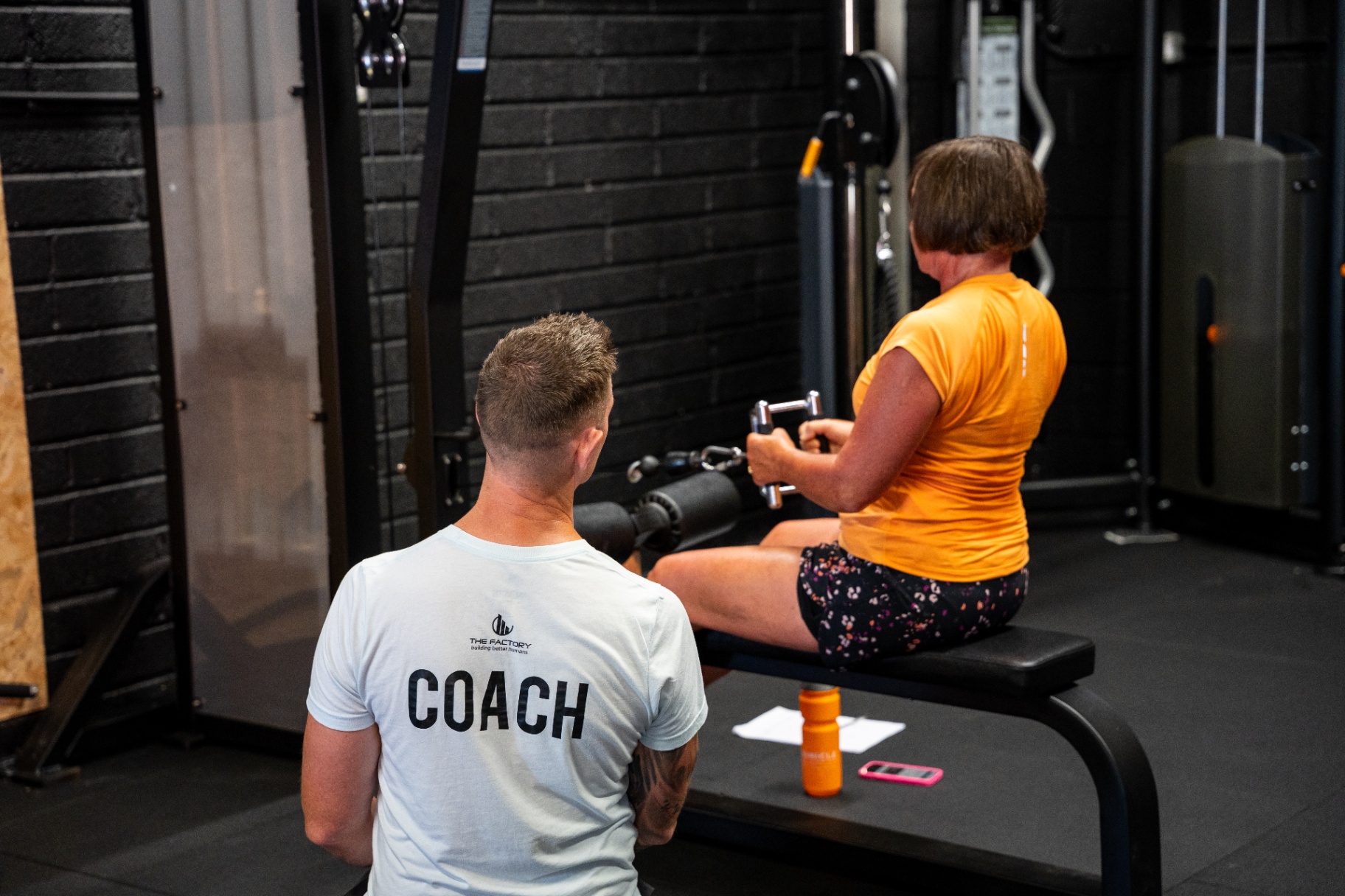 Coach supervising a seated row training session