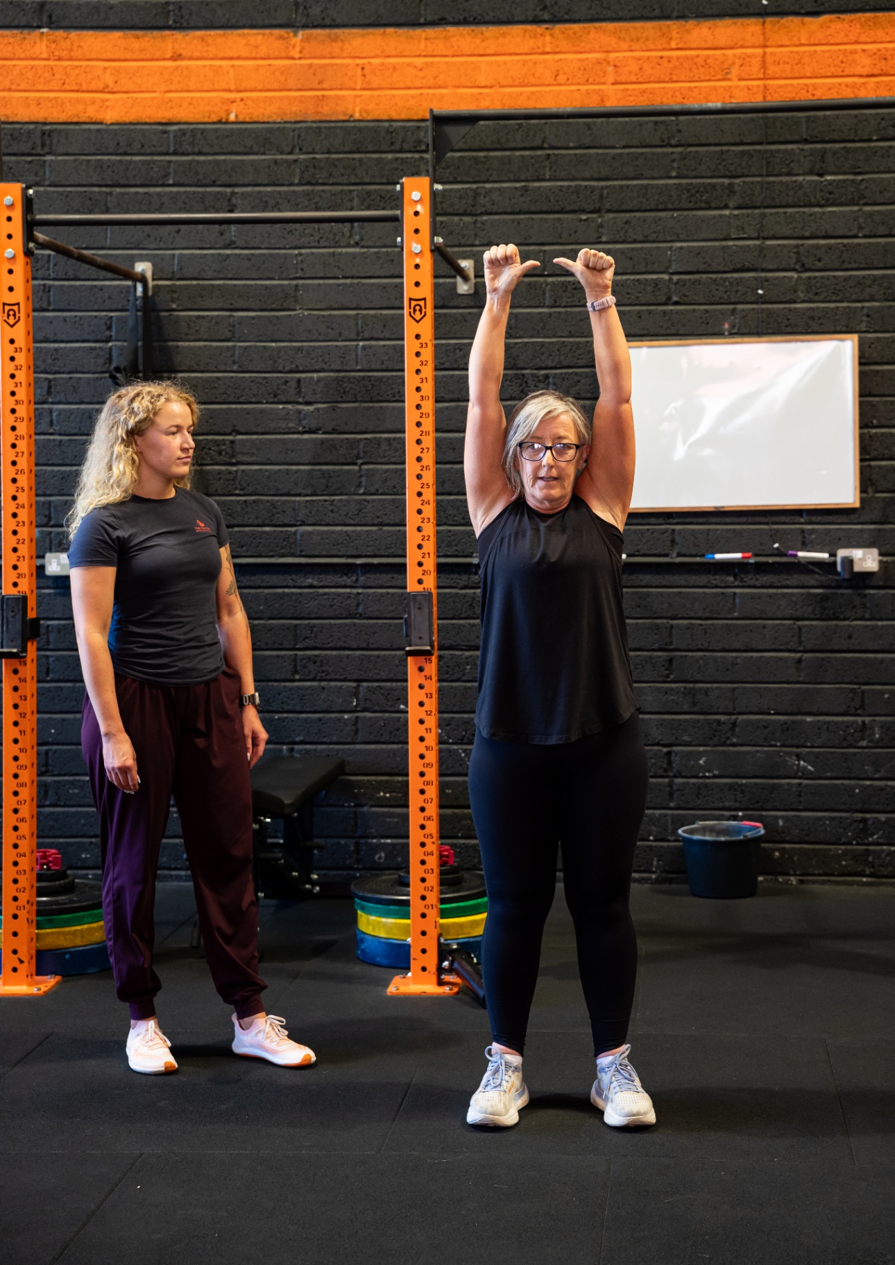 Coach demonstrating a stretch with a client