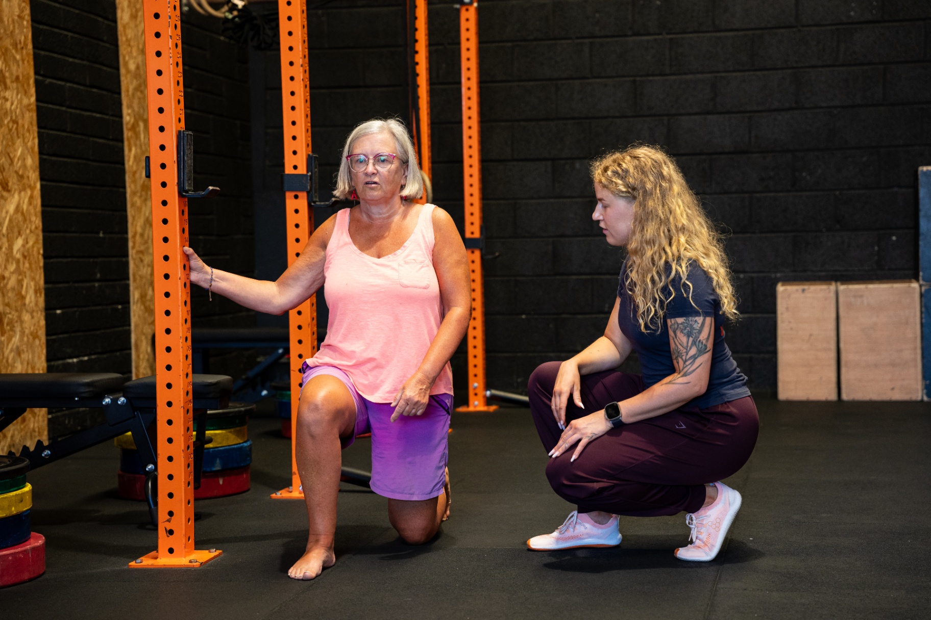 Coach helping a client with a kneeling stretch