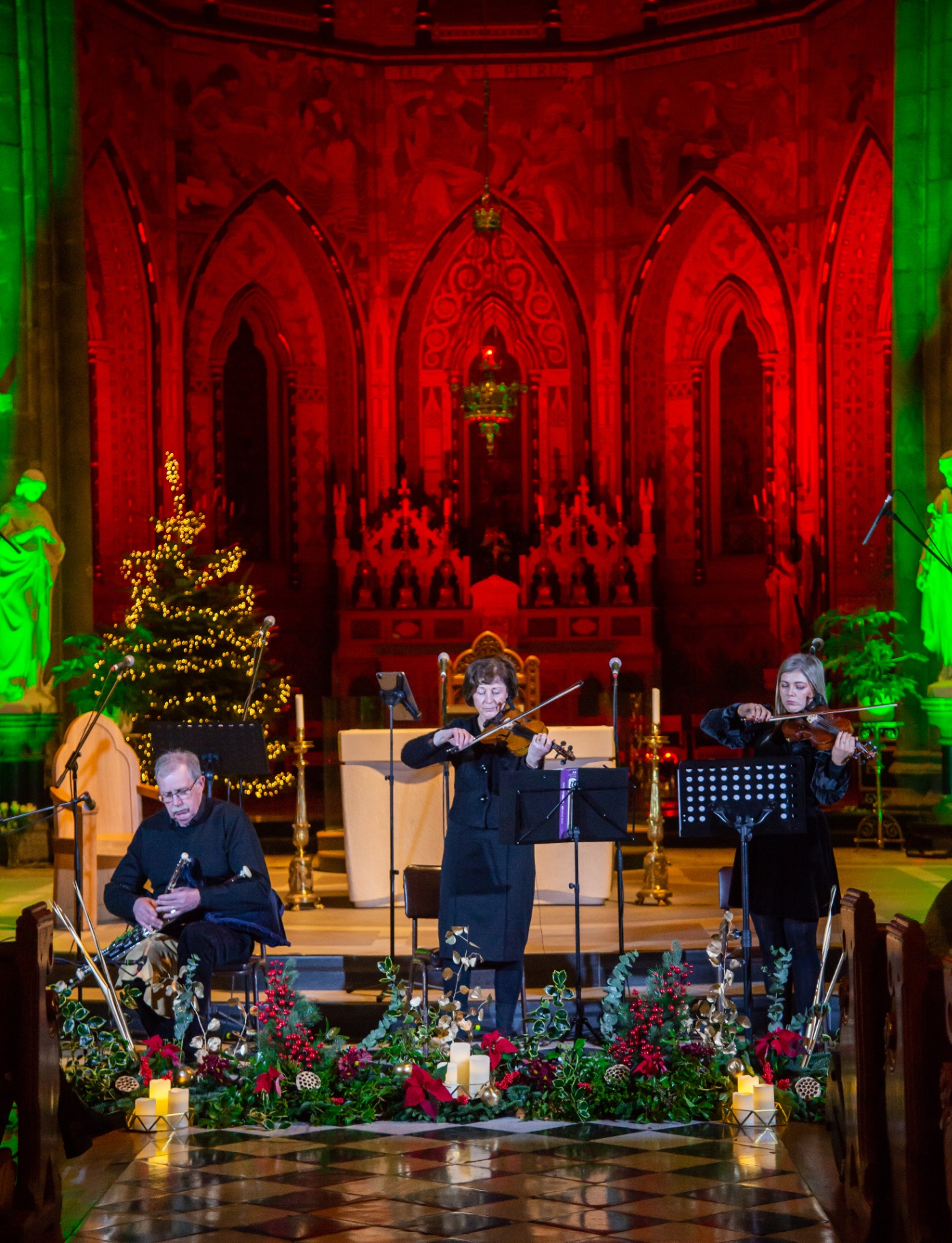 String quartet performing in a cathedral with festive lighting