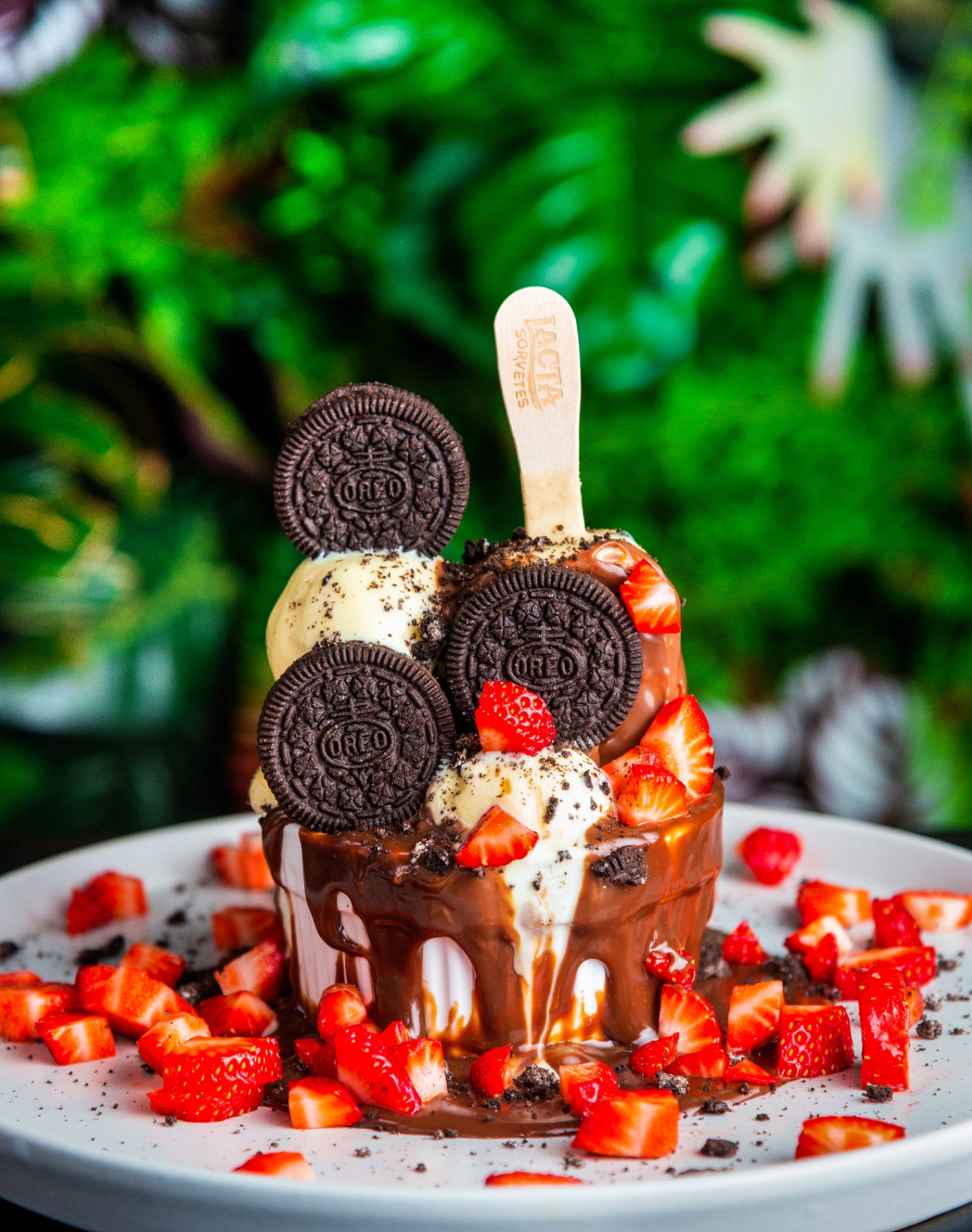 Chocolate-drizzled ice cream sundae with Oreo cookies and fresh strawberries
