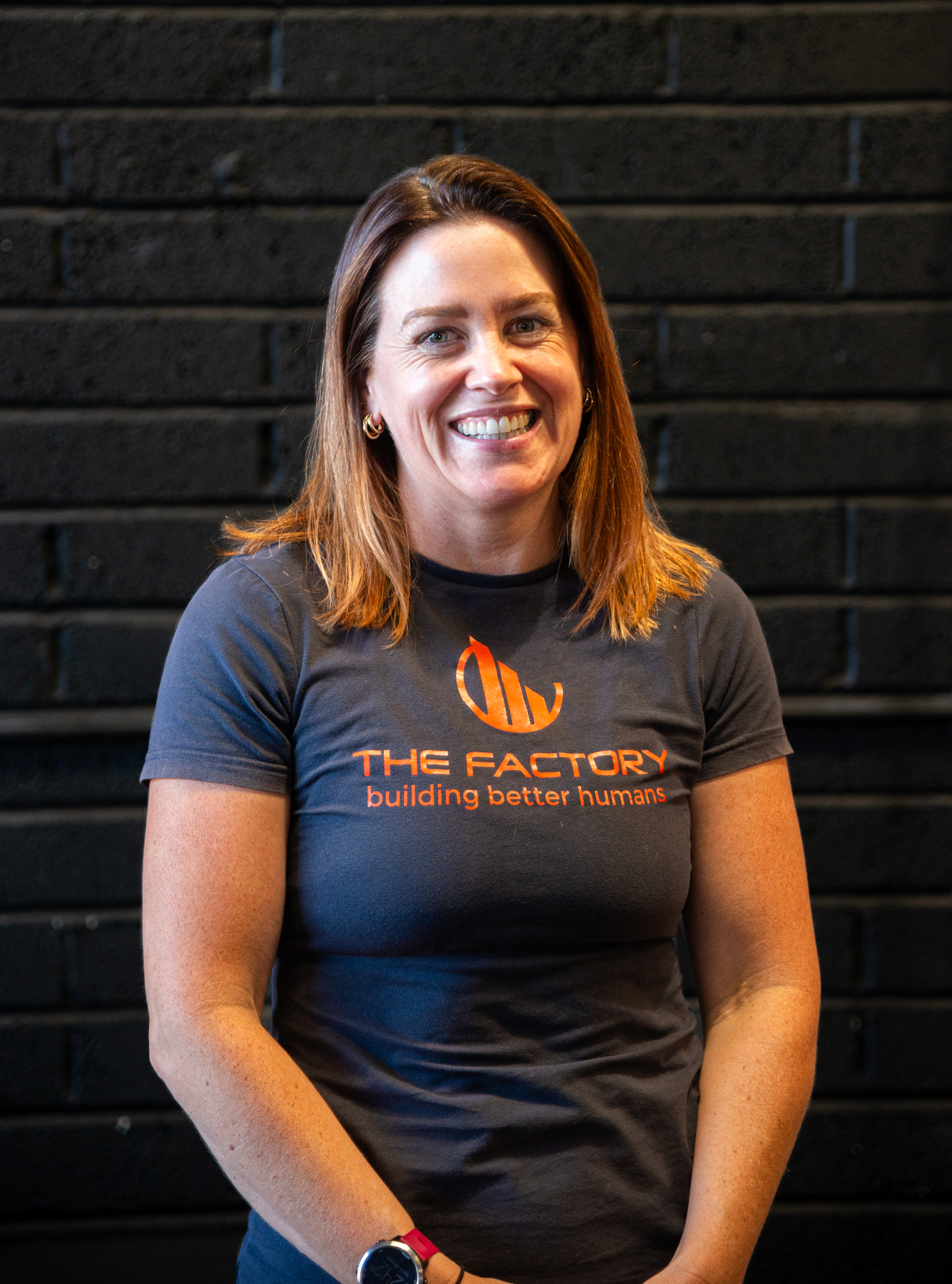 Smiling woman with auburn hair in a branded gym t-shirt