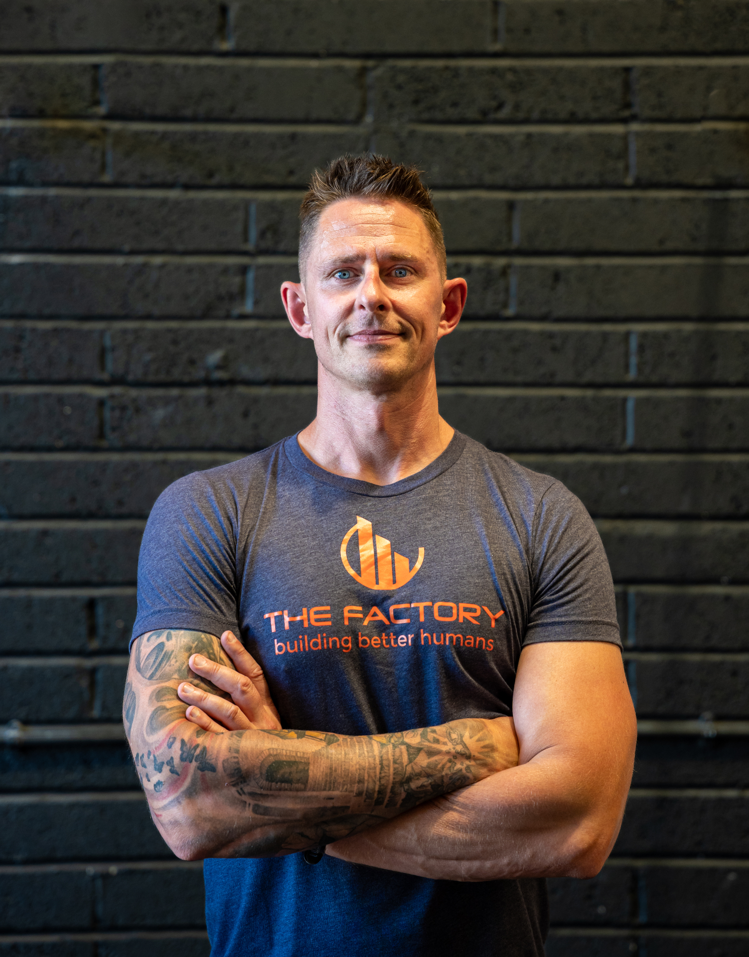 Confident man with tattooed arms in a branded gym t-shirt